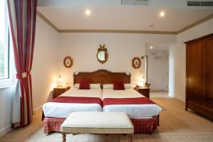 a bedroom with a large bed with red curtains at Gran Hotel Pelayo in Covadonga +97 photos