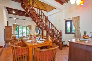a dining room with a table and a staircase at Tropical Family Retreat near Ya Nui Beach - Villa Nikkie in Nai Harn Beach