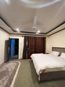 a bedroom with a large bed and a ceiling at Hills n Huts in Hini