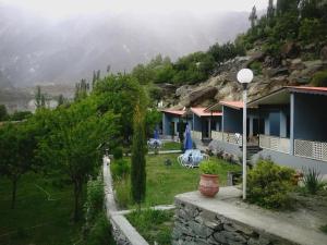 a group of houses in a field with a mountain at Hills n Huts in Hini