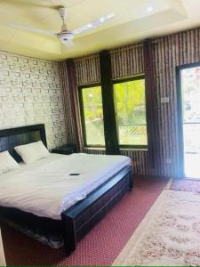 a bedroom with a large bed and two windows at Hills n Huts in Hini