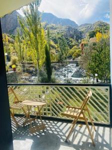 two chairs and a table on a balcony with a view at Hills n Huts in Hini