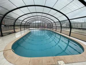 an indoor swimming pool with a glass ceiling at Le clos du Breuchin in Breuchotte +6 photos