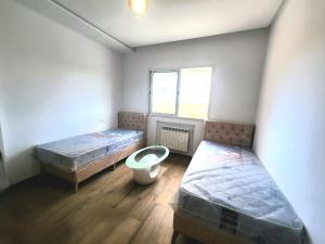 a room with two beds and a window at s2 fontaine in Nabeul