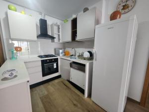 a kitchen with white cabinets and a white refrigerator at s2 fontaine in Nabeul