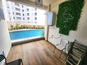 a room with a swimming pool and a room with a chair at s2 fontaine in Nabeul