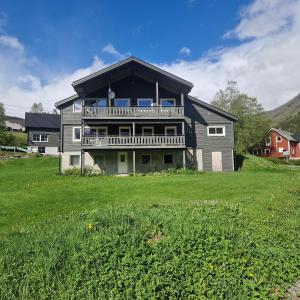 a large house with a large yard in front of it at Mørkve Apartement in Myrkdalen