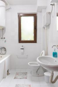 a white bathroom with a sink toilet and a window at Apartment Bojke in Niš +32 photos