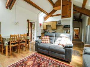 a living room with a couch and a table at Bythyn Ddol Hafod in Capel Curig