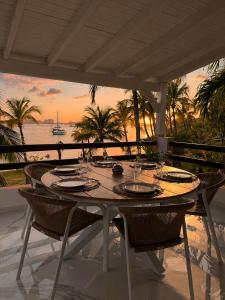 a table on a patio with a view of the ocean at Sunset Paradise in Baie Nettle