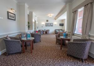 a hotel lobby with couches and tables and chairs at The Hickstead Hotel By Uno-FREE PARKING in Bolney
