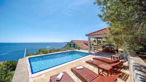 a house with a swimming pool next to the ocean at Apartman Mario with pool by Villas Guide in Blato