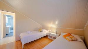 a attic room with two beds and a window at Apartman Mario with pool by Villas Guide in Blato +23 photos