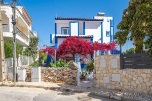 a blue and white building with a tree with red flowers at Don Sidónio Alojamentos in Portimão