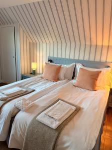 a bedroom with a large white bed with pillows at Kullagård Hotell in Mölle