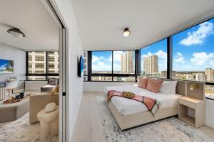 a bedroom with a bed and large windows at District 225 Condo by Ionica in Miami