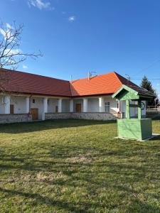 a house with an orange roof and a yard at Tornácos Vendégház in Szécsény