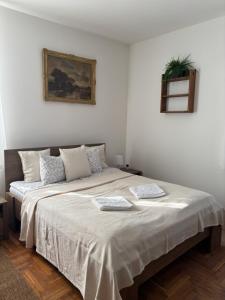 a bedroom with a large bed with two towels on it at Tornácos Vendégház in Szécsény