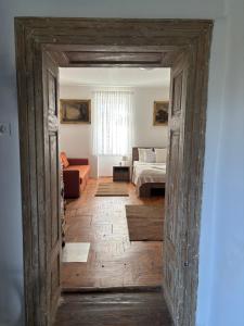an open door into a bedroom with a bed and a couch at Tornácos Vendégház in Szécsény +3 photos