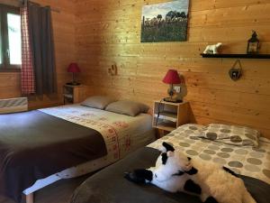 a bedroom with two beds and a dog laying on the bed at Chalet Isard in Gère-Belesten