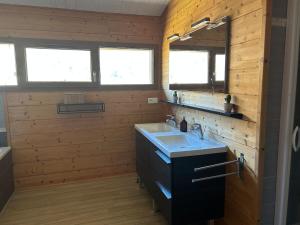 a wooden bathroom with a sink and a mirror at Chalet Isard in Gère-Belesten +18 photos
