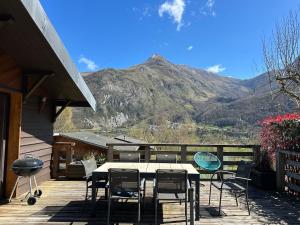 a table and chairs on a deck with a mountain at Chalet Isard in Gère-Belesten