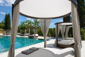 a room with a canopy bed next to a swimming pool at Barceló Roma in Rome