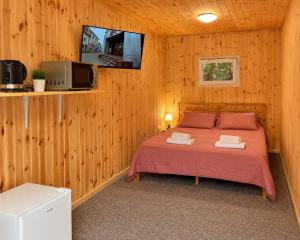 a bedroom with a bed in a wooden room at Pool Hause Palanga in Palanga