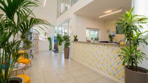 De lobby van een winkel met potplanten. bij Sisan Family Resort in Bardolino