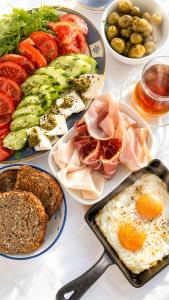 a table topped with plates of food with eggs and bread at Каюта in Kotor