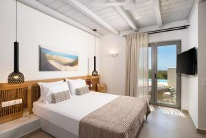 a bedroom with a bed and a television and a balcony at Aegean Hospitality in Mikonos +78 photos