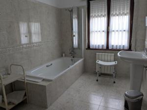 a white bathroom with a tub and a sink at Posada La Merced in Loredo +19 photos