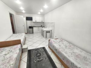 a small room with two beds and a kitchen at Rassvet in Lenīnogorsk