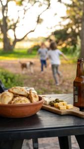 a bowl of bread and cheese and a bottle of beer at Cabañas Tierra Linda in Concepción del Uruguay