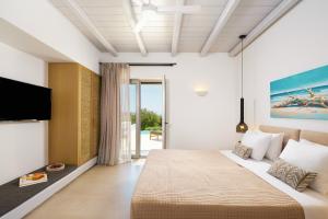 a hotel room with a bed and a tv at Aegean Hospitality in Mikonos