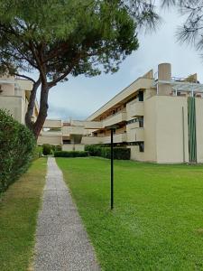a building with a sign in the grass in front of it at Ohana Resort in Marina di Bibbona