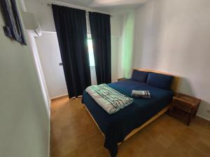 a bedroom with a blue bed and a window at lagoon apartment 2 in Moulay Bousselham