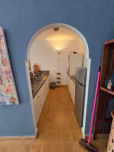 a kitchen with an archway and a refrigerator in a room at lagoon apartment 2 in Moulay Bousselham