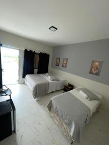 a hotel room with two beds in a room at Hotel Acqua Park in Capim Grosso