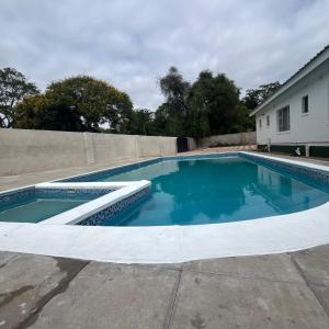 a swimming pool with blue water in a yard at Cumberland Guest Lodge in Bulawayo
