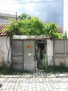 a woman standing in the doorway of a building at At Home Hostel in Korçë
