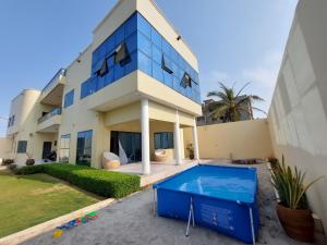 a house with a swimming pool in front of it at villa face à la mer in Cotonou
