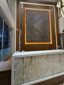 a painting on a wall above a counter in a room at Hotel Nova Platinum Ujjain in Makoria Ām +56 photos