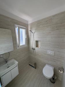 a bathroom with a white toilet and a sink at Hotel SKURA , Librazhd in Librazhd +8 photos