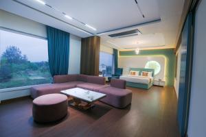 a living room with a couch and a bed at Hotel Nova Platinum Ujjain in Makoria Ām