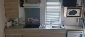 a small kitchen with a sink and a microwave at Camping 2 étoiles - Piscine - ccbfida in Vernet-les-Bains