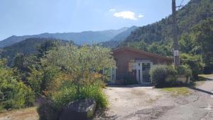 a small house with mountains in the background at Camping 2 étoiles - Piscine - ccbfida in Vernet-les-Bains