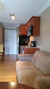 a living room with a couch and a kitchen at Condo St Sauveur in Piedmont