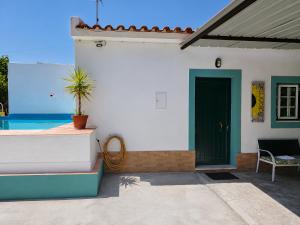 a house with a green door and a pool at Quinta da Ponte das Hortas 2 in Elvas