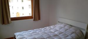 a white bed in a room with a window at Studio in St Moritz Champfer in St. Moritz
